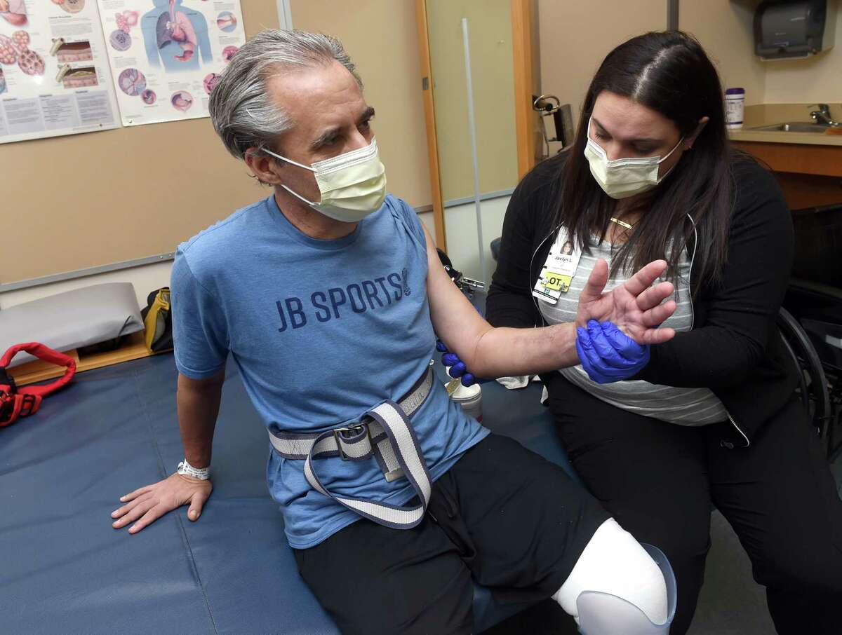 Occupational Therapist Jaclyn Lavigne, right, works on range of motion with John Bysiewicz's arm at Gaylord Hospital in Wallingford.