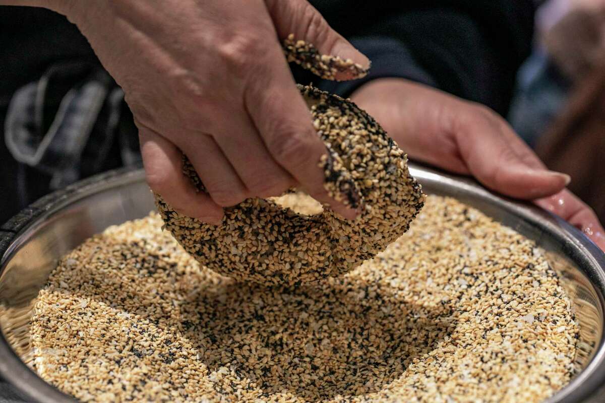 Poppy baker Sonia Hernandez coats a bagel in everything-flavored seeds and spices from Oaktown Spice Shop.