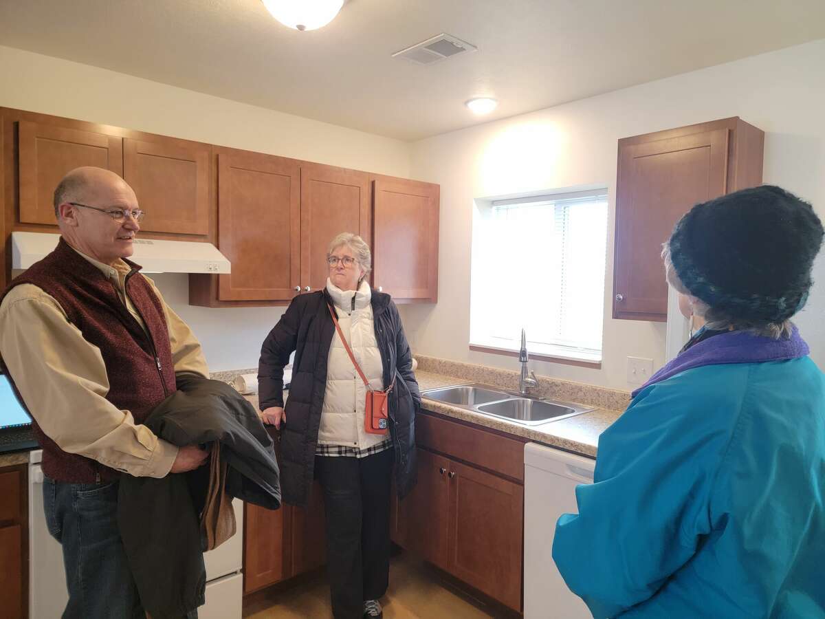 Jon Stimpson, executive director of Homestretch, talks with visitors to the show apartment during an open house held to celebrate the opening of the village of Honor apartments on Jan. 27. 