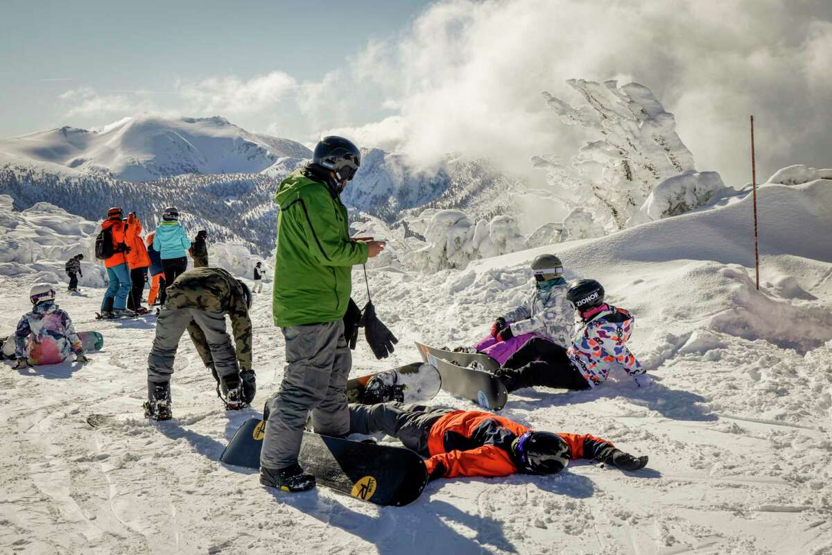 Snowboarders rest near the Sky Express chairlift at Heavenly Mountain Resort.