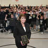 Diane Fulco poses in front of the wrestling team with the Lasting Impact Award she is receiving for years of volunteering and support of the Trumbull High School wrestlers, seen here in Trumbull, Conn. Jan. 27, 2023.