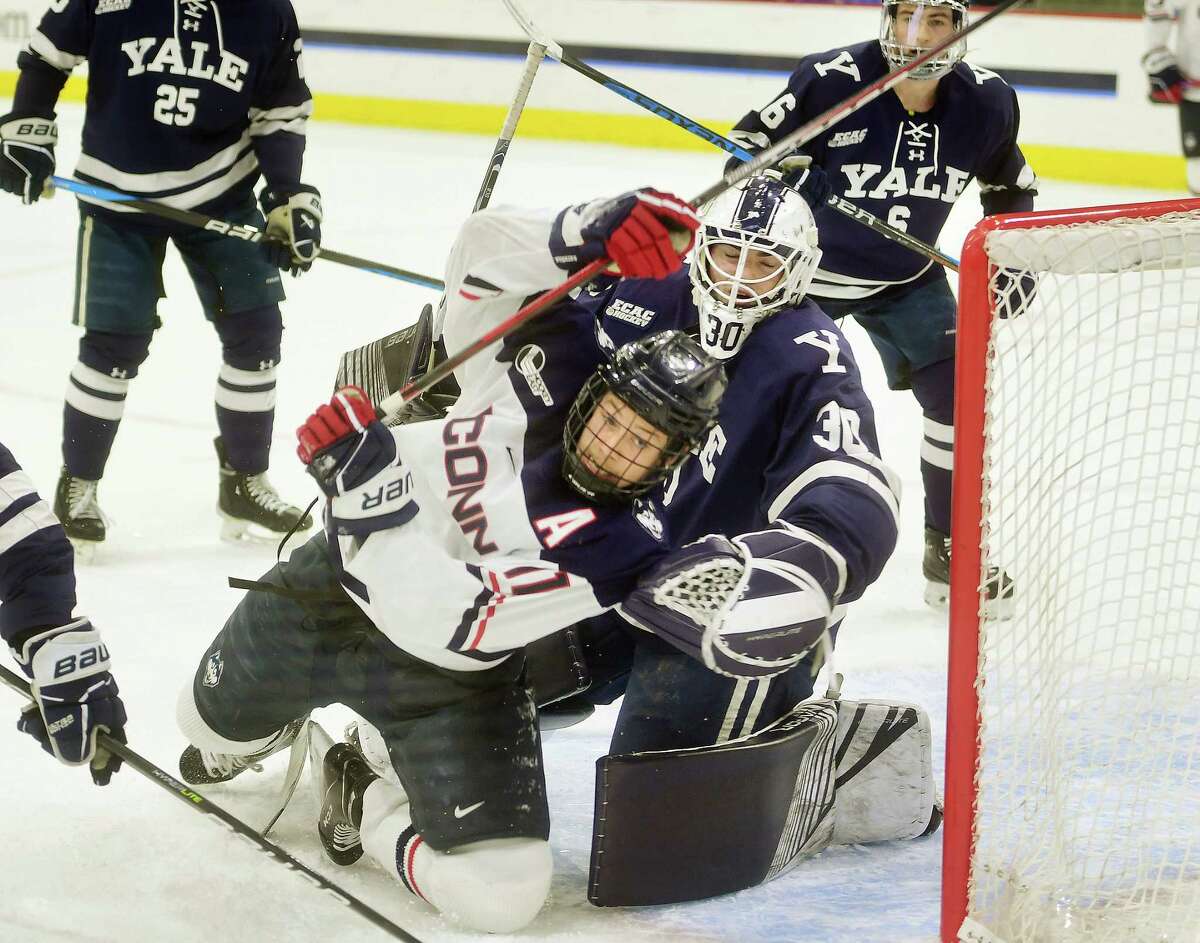 UCONN's Ty Amonte gets tied up with Yale goalie Luke Pearson in the first period of UCONN's win in the opening game of the annual Connecticut Ice college hockey tournament at Quinnipiac University in Hamden, Conn. on Friday, January 27, 2023.