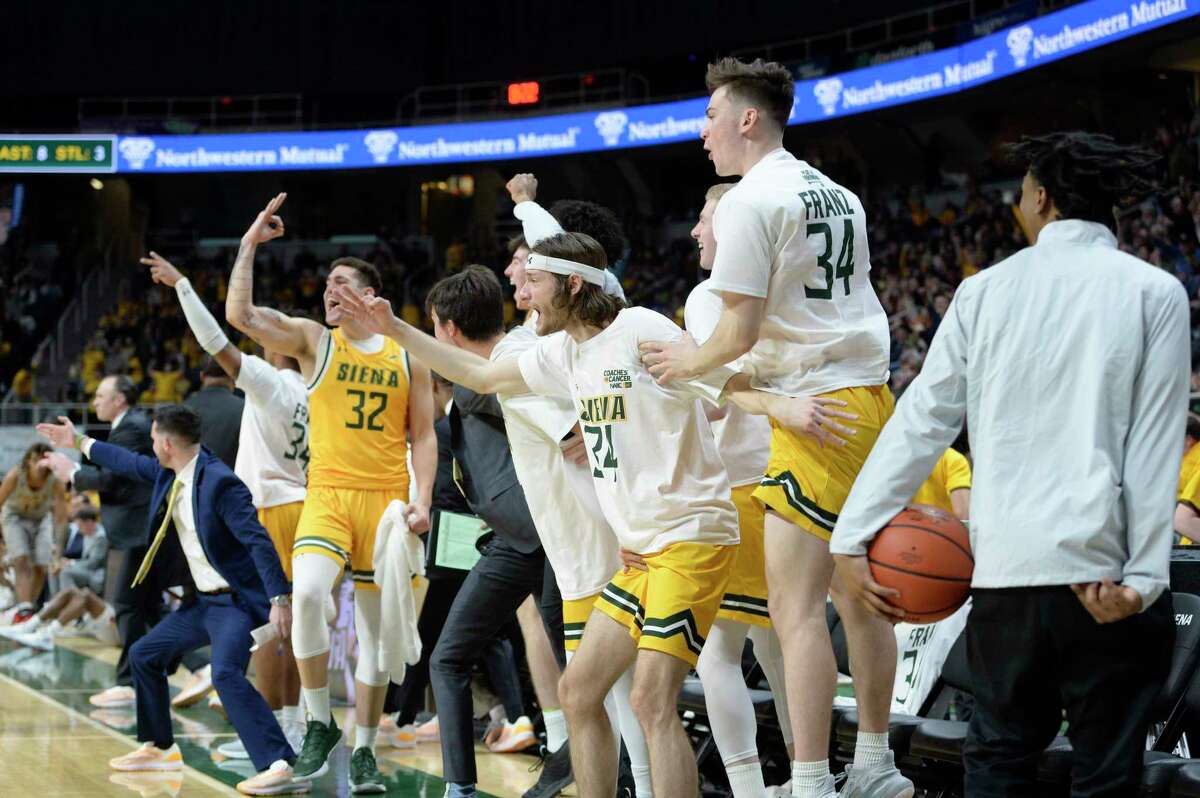 Siena basketball players on the bench react to a 3-point basket made by Michael Baer during a game at MVP Arena in Albany on Friday, Jan. 27, 2023.