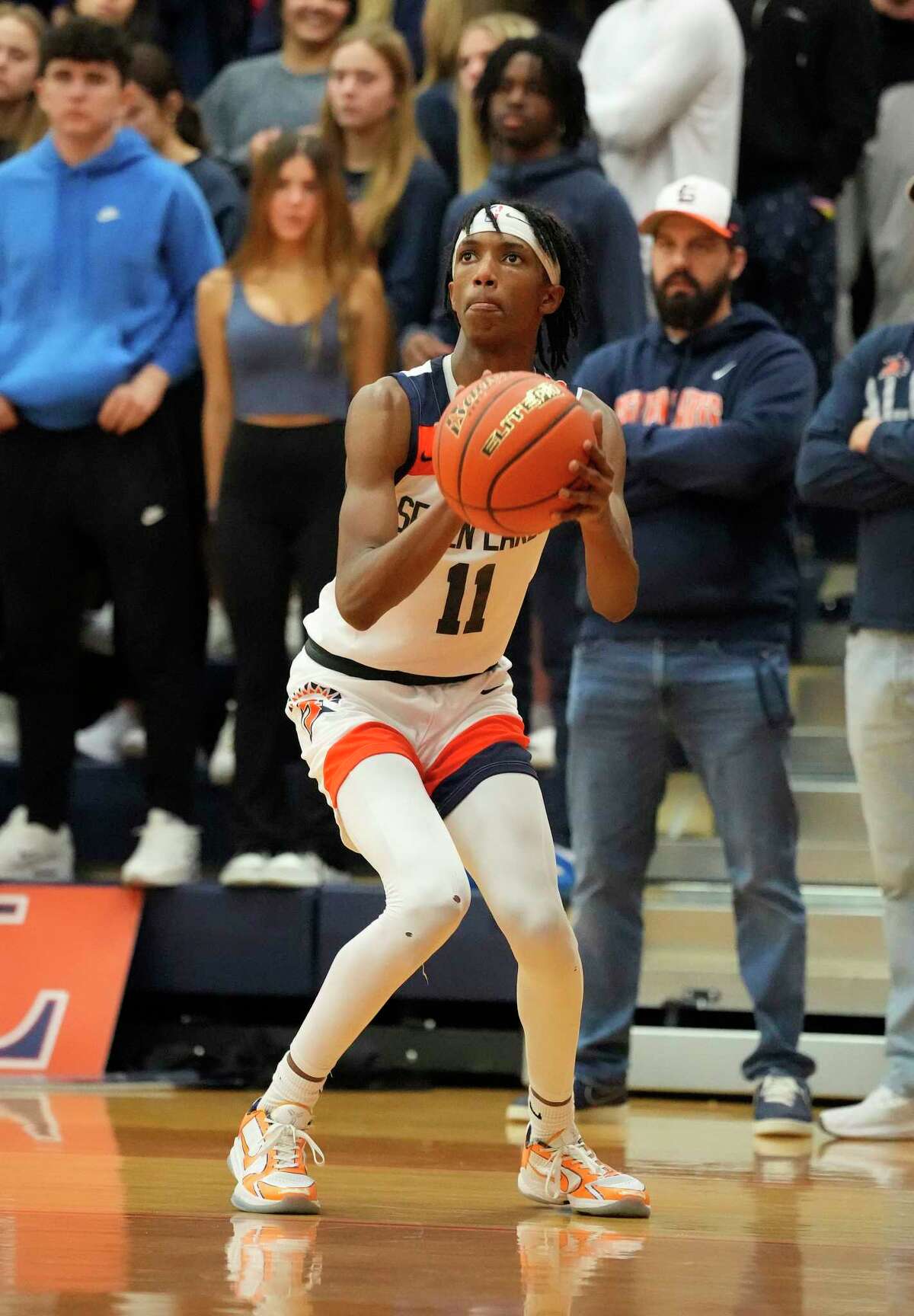 Seven Lakes High School's Nasir Price (11) sets up for a three-pointer during the second half of a District 19-6A boys basketball game at Seven Lakes High School on Friday, Jan. 27, 2023 in Katy. Seven Lakes High School beat Jordan High School82-72.