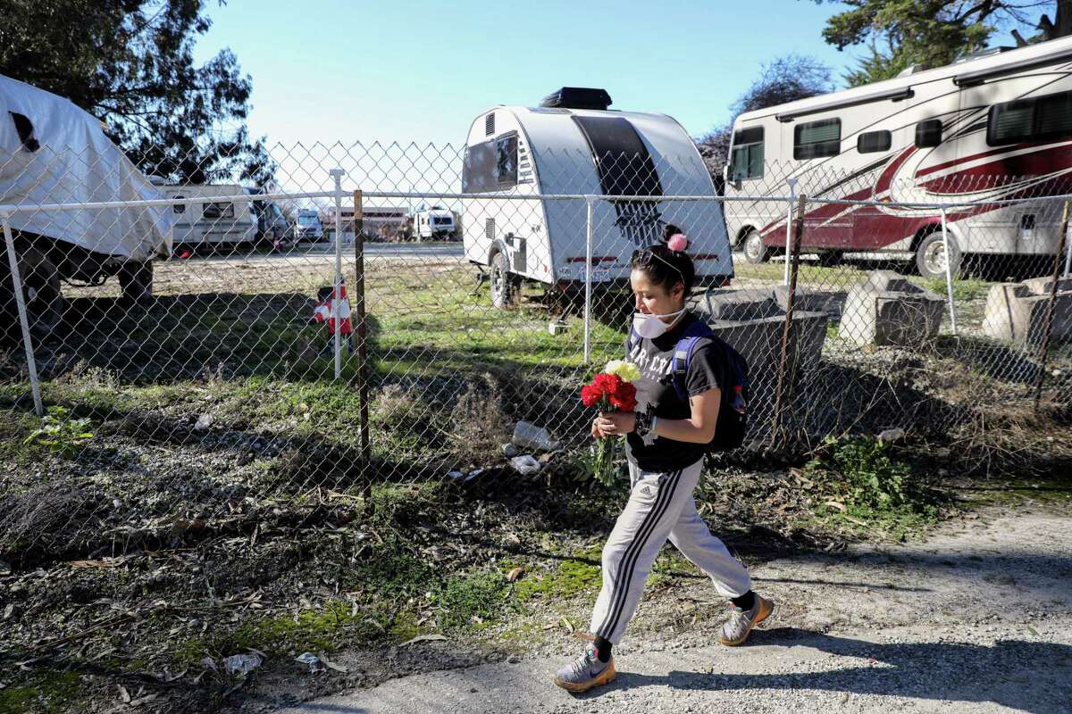 Amairani Cortes walks to the gate at California Terra Garden on Thursday to leave flowers near the site of last week’s mass shooting. Police have charged 66-year-old Chunli Zhao, who was a worker at California Terra Garden, with seven counts of murder as well as attempted murder.