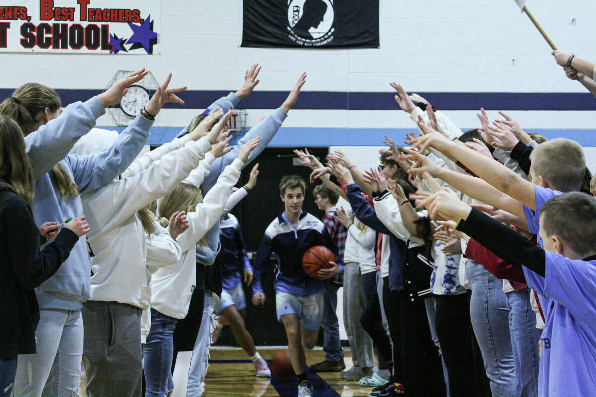 The Brethren student section makes a tunnel as the Bobcats make their way to the floor for warmups against Manistee Catholic Central on Jan. 27, 2023 at Brethren High School. 