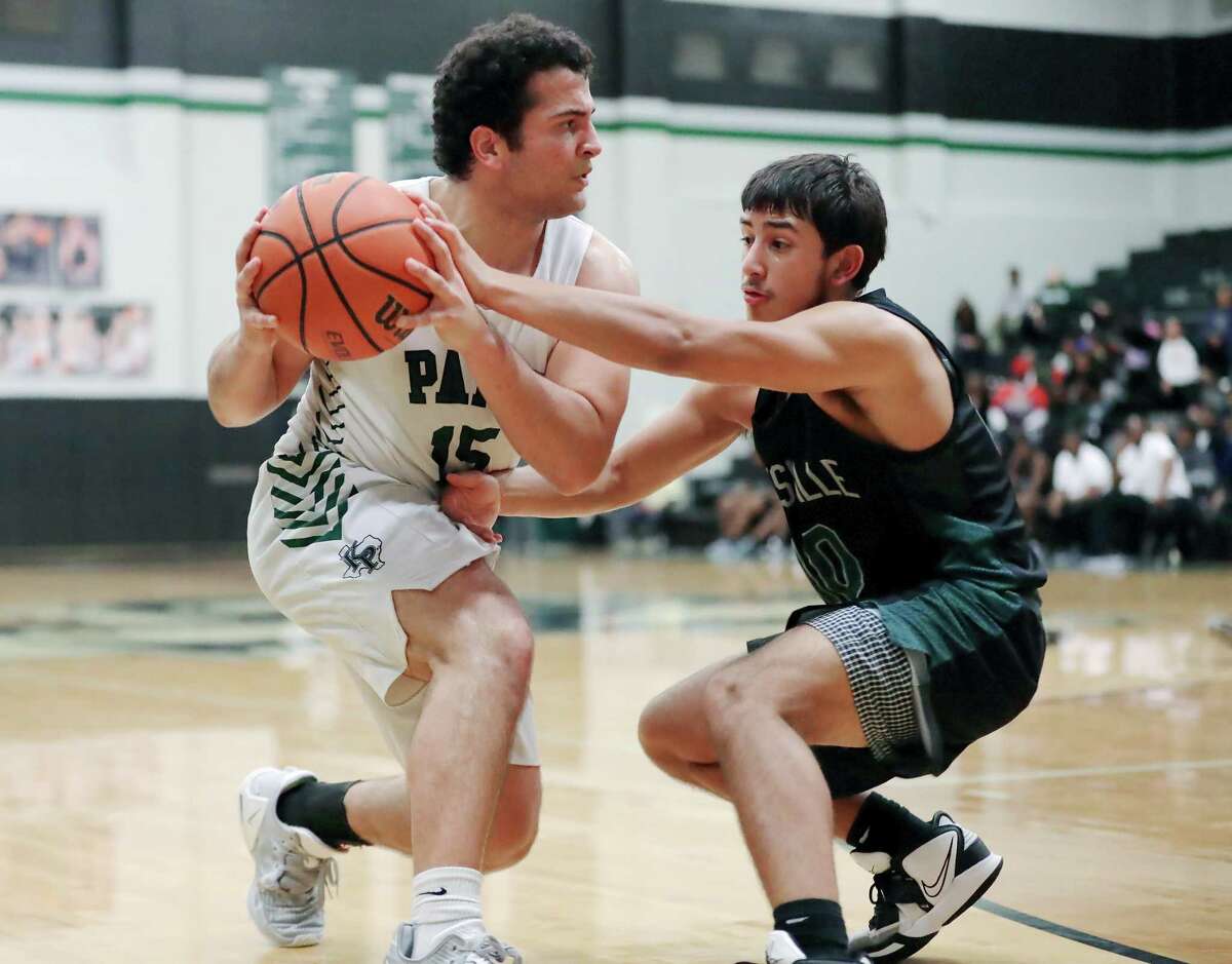 Kingwood Park’s Juan Flores, left, looks to pass the ball as Huntsville’s Brayden Rozell, right, reaches in during their District 16-5A basketball game, held at Kingwood Park High School Friday, Jan. 27, 2023 in Kingwood, TX.