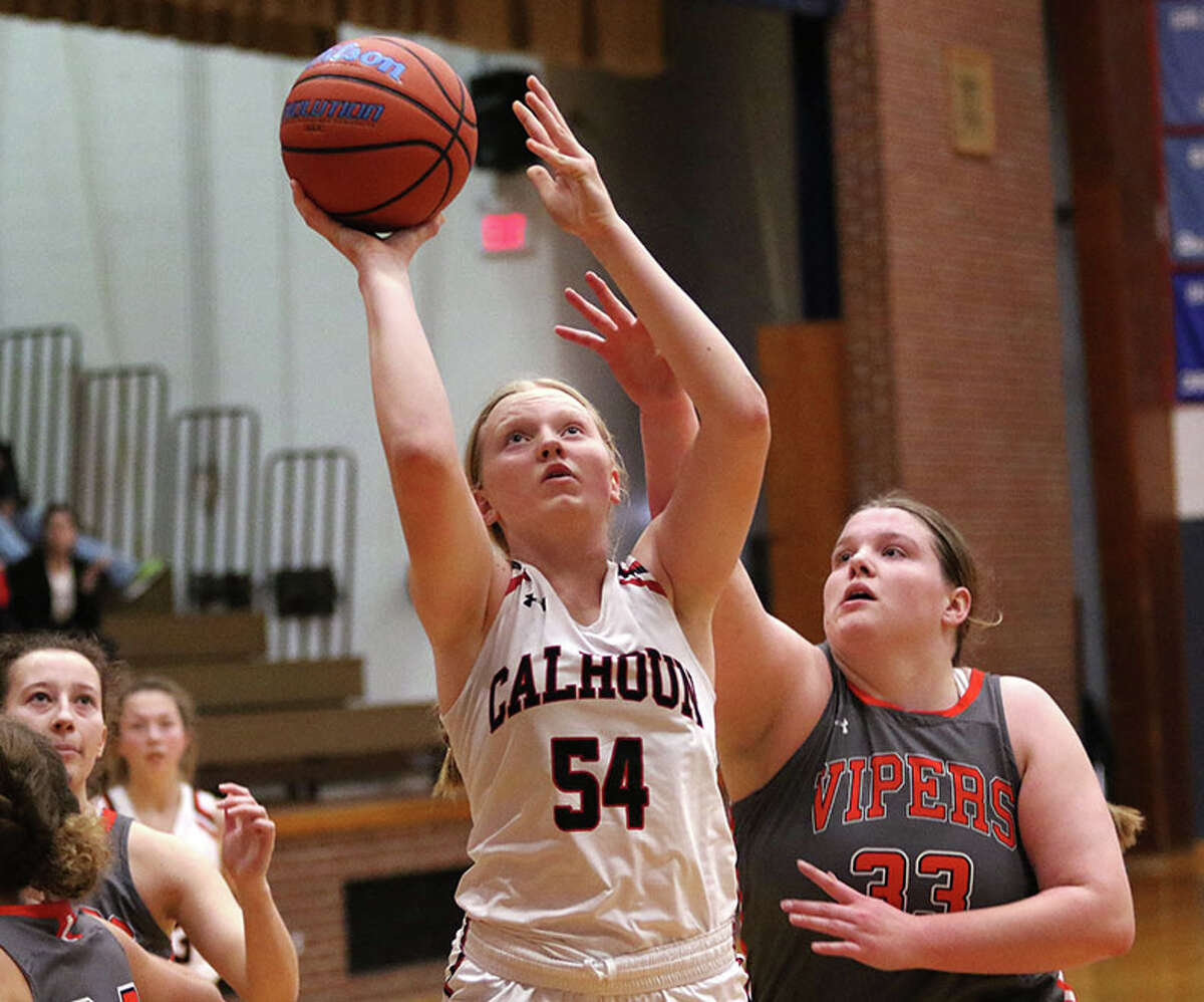 Calhoun's Audrey Gilman (54) scores in front of South County's Marissa Heironimus in a game at the Carlinville Tourney in December. On Friday night, Gilman scored 19 points in the Warriors' win over Marquette Catholic at the Carrollton Tourney.