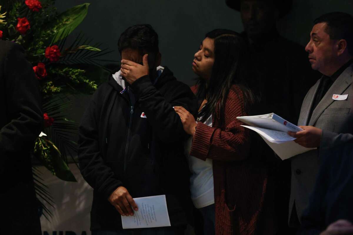 Moments after Servando Martinez Jiminez (left) spoke about his brother Marciano Martinez Jiminez, who was killed in this week’s Half Moon Bay mass shootings, he is comforted by his daughter Marisela Martinez- Maya (center) at a community vigil for victims in Half Moon Bay on Friday.