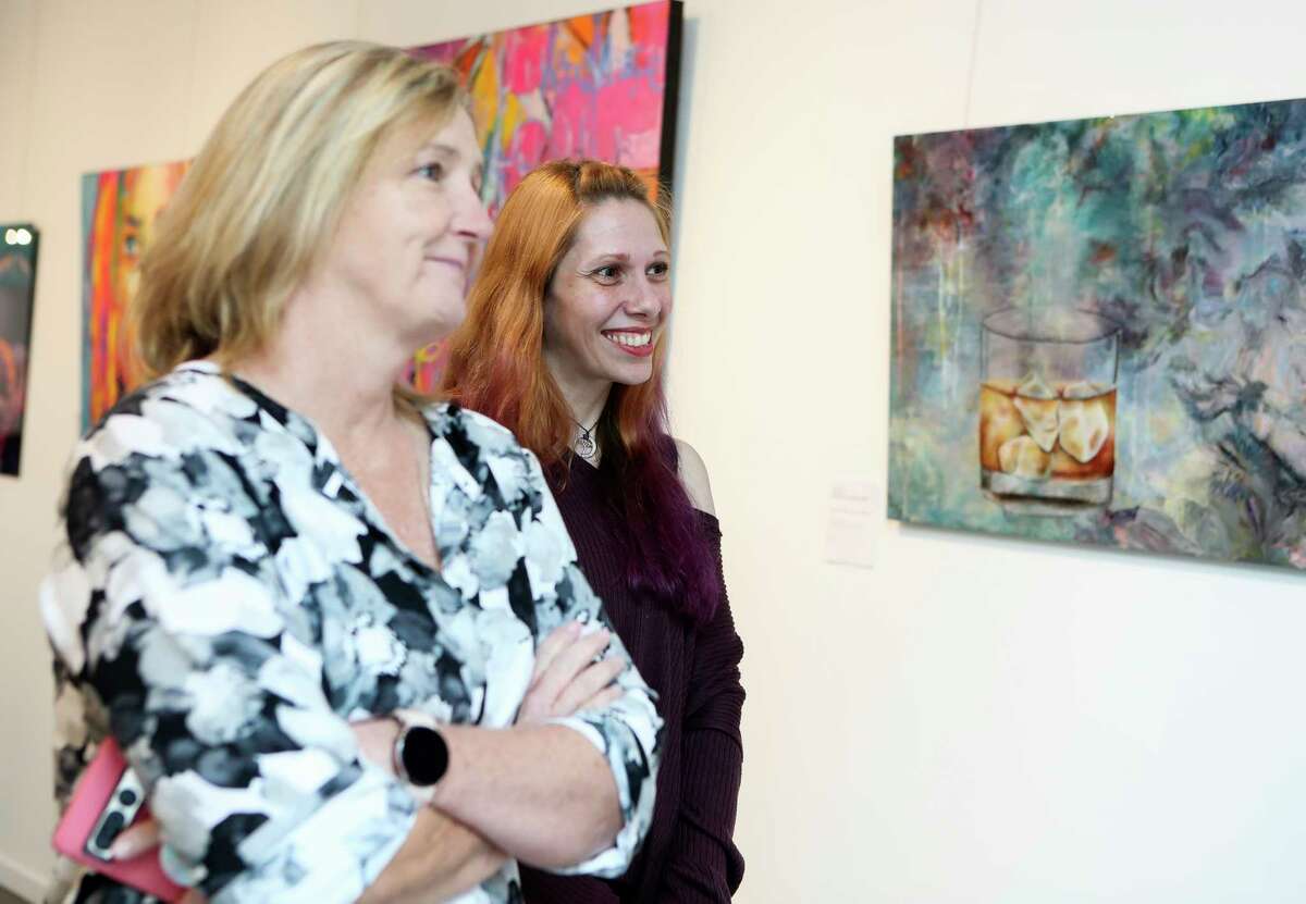 Montgomery County artists Toria Hill, left, and Rebekah Molander look over her recent work during an exhibition at the Glade Arts Foundation to benefit those affected by December’s arson fire which destroyed Winter Street Studios, Saturday, Jan. 28, 2023, in The Woodlands.