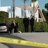 Police investigators stand in a street near a house where three people were killed and four others wounded in a shooing at a short-term rental home in an upscale Los Angeles neighborhood on Saturday Jan. 28, 2023.
