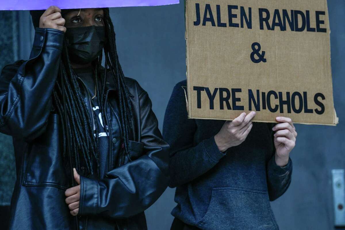 Maiya Miller, 24, and Lena Craven, 24, hold signs amongst a group of people that gathered at the federal courthouse in downtown Houston on Saturday, Jan. 28, 2023, to protest the killing of 29-year-old, Tyre Nichols by Memphis police officers.