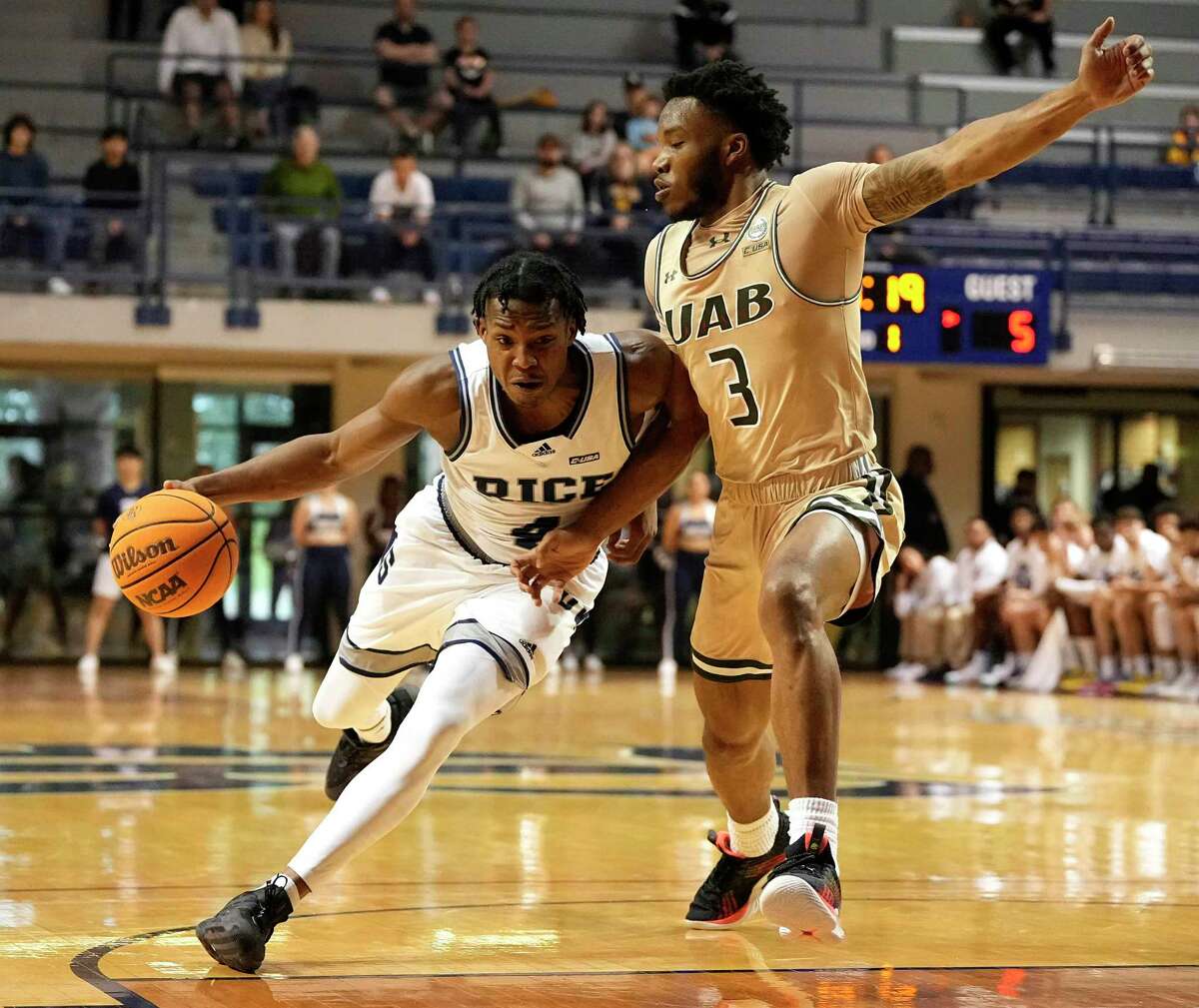 Rice Owls guard Quincy Olivari (4) drives the lane while defended by UAB Blazers guard Tavin Lovan (3) during the first half of an NCAA college basketball game at Tudor Field House, Saturday, Jan. 28, 2023, in Houston.