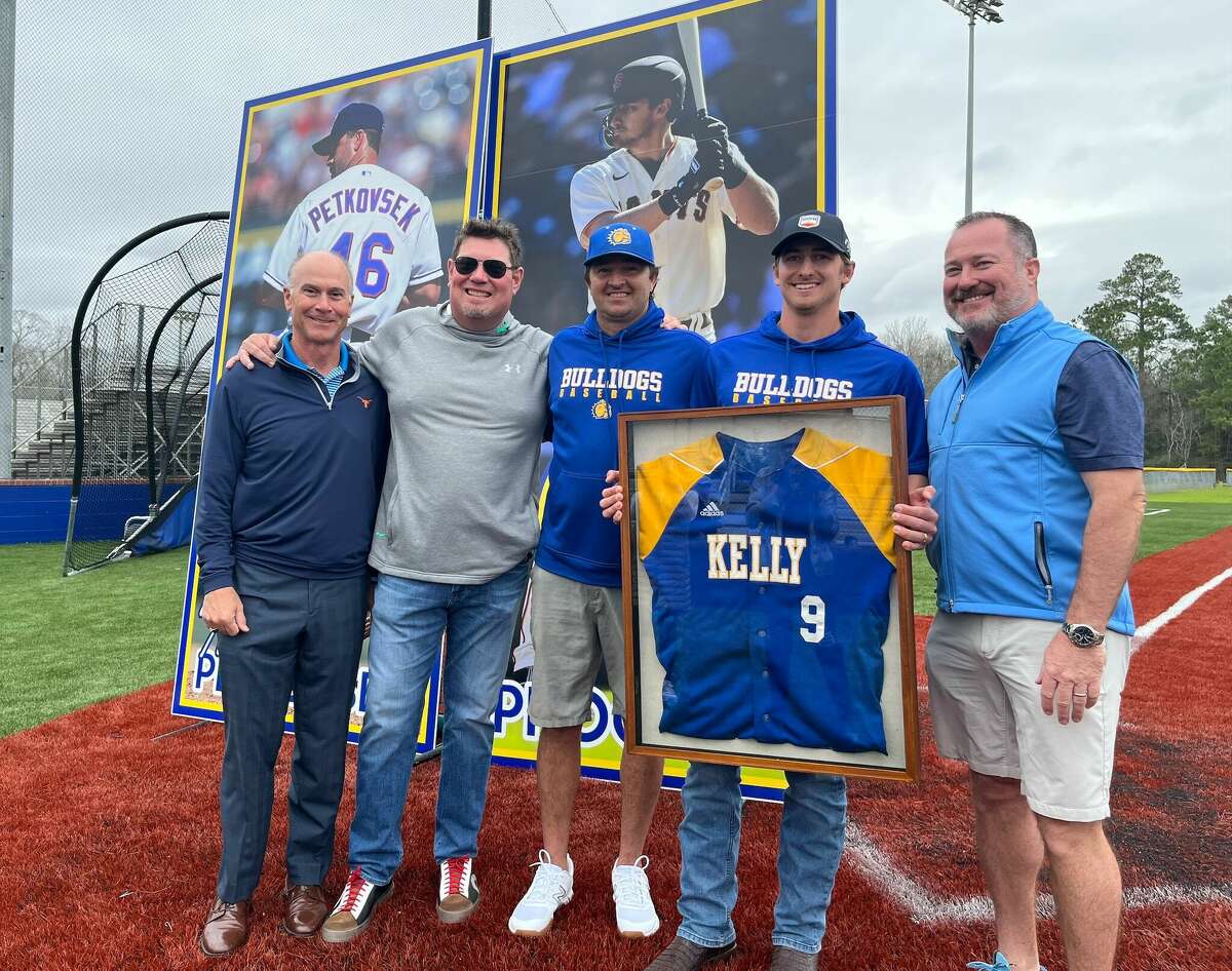 Ford Proctor holds his Kelly Catholic baseball jersey while standing next to his youth and high school coaches on Saturday, Jan. 28, 2023. 