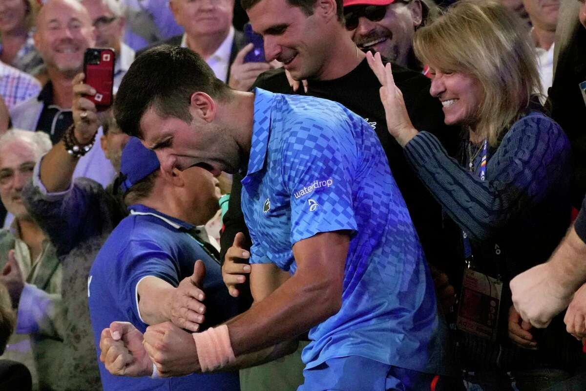 Novak Djokovic of Serbia celebrates in the stands with his support team after defeating Stefanos Tsitsipas of Greece in the men's singles final at the Australian Open tennis championship in Melbourne, Australia, Sunday, Jan. 29, 2023.