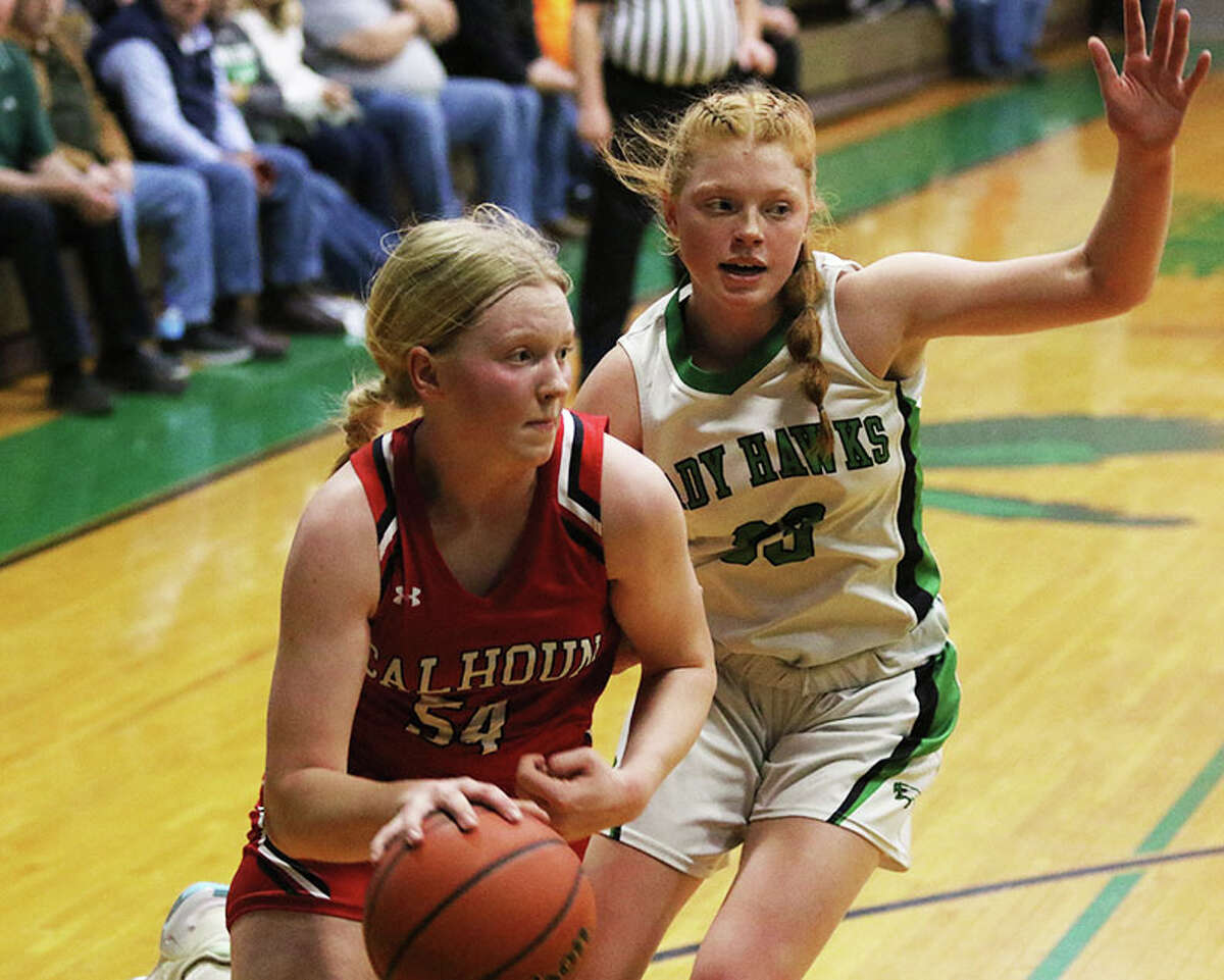 Calhoun's Audrey Gilman (left) drives baseline on Carrollton's Lauren Flowers in the first half Saturday in the fifth-place game at the 48th annual Lady Hawks Invite at Carrollton.