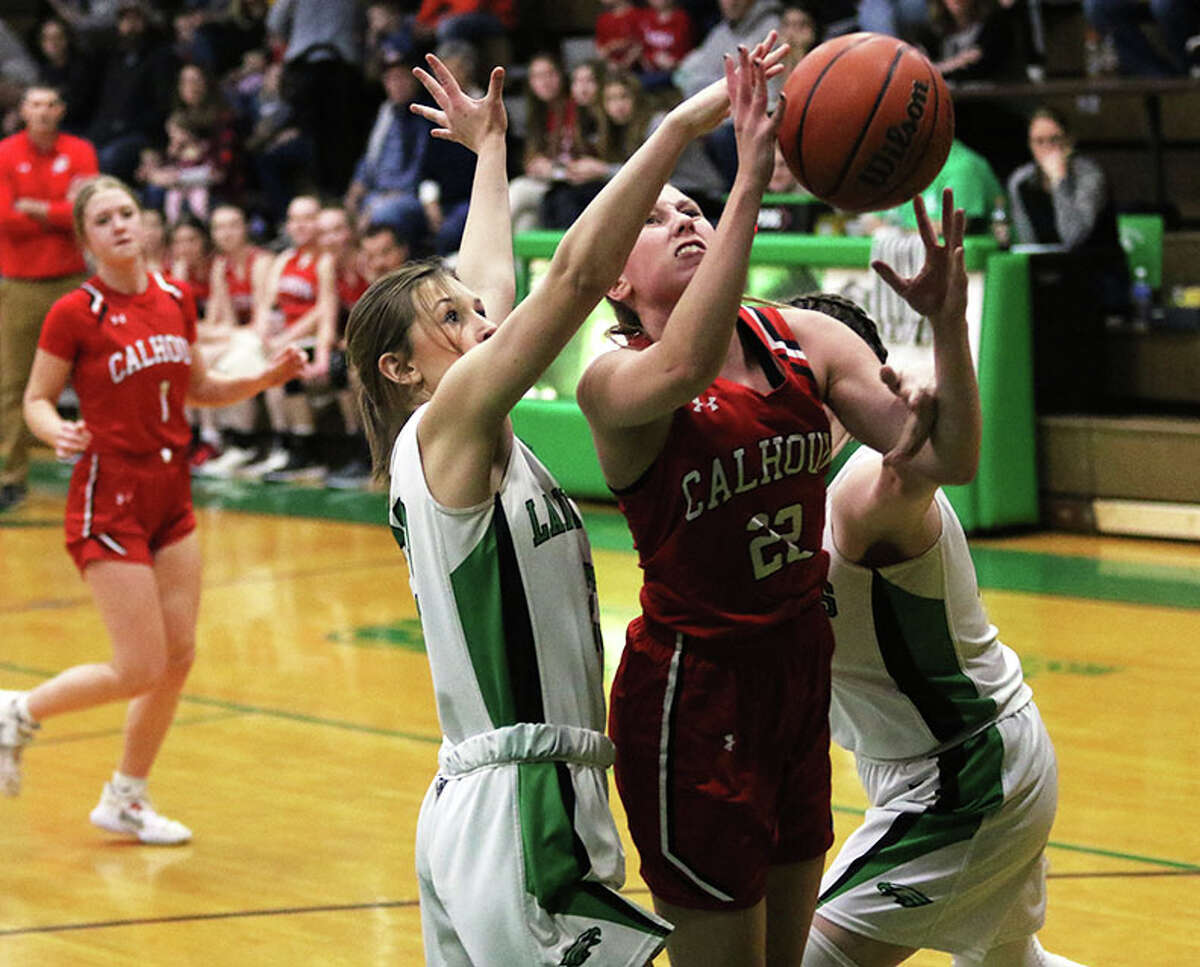 Calhoun's Haley Schnelten (22) has her shot knocked out of bounds by Carrollton's Harper Darr (second left) on Saturday in the fifth-place game at the 48th annual Lady Hawks Invite at Carrollton.