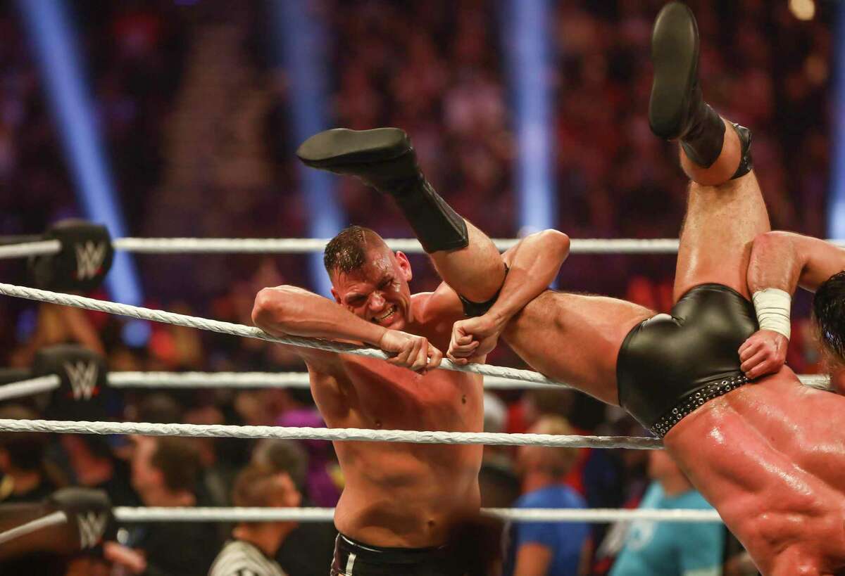 WWE superstar Gunther holds onto Drew McIntyre’s leg as he hangs over the ropes during the Men’s Royal Rumble match held at the Alamodome in San Antonio, Texas, on Jan. 28, 2023.