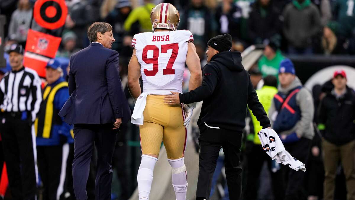 49ers defensive end Nick Bosa walks off the field with trainers during the first half of the NFC championship game between the Niners and the Eagles in Philadelphia.