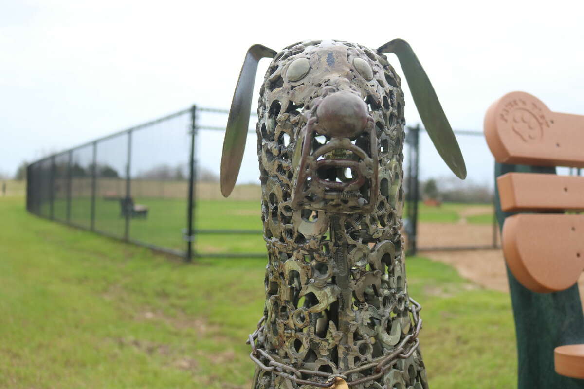A statue made of scrap metal including wrenches and spark plugs stands outside League City's new dog park.