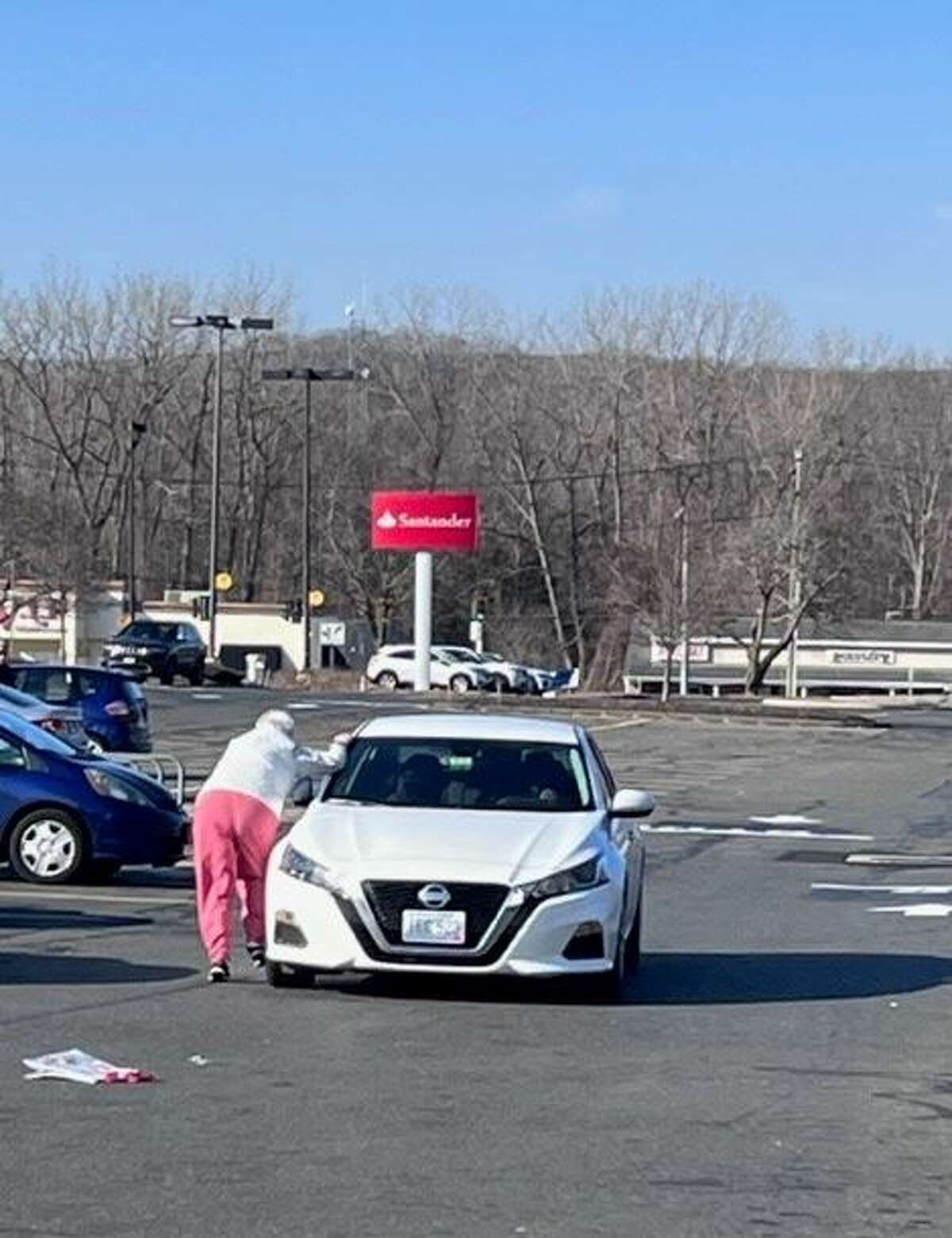 A woman struggles to regain her footing after thieves stole her purse in the parking lot of Walmart in Southington Monday. Police say the car they were in had been stolen. The purse-snatching is the latest of a series of similar crimes. 