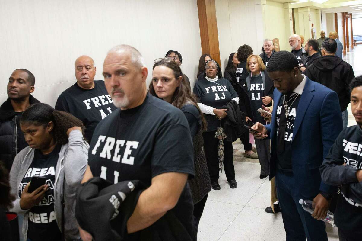 Antonio Armstrong Jr. supporters wearing “Free AJ” and “Enough is Enough Free AJ” t-shirts and haning outside the hallway of the 179th District Court Monday, Jan. 30, 2023, at Harris County Criminal Justice Center in Houston. Judge Kelli Johnson ordered both sides in the Antonio Armstrong Jr. capital murder case to argue why his third trial, following two rounds of hung juries, should or should not be moved to another county. The judge decided the case will stay in Harris County.