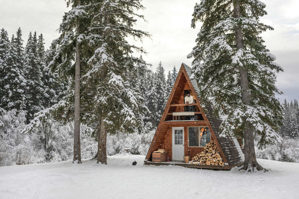 There's something cozy about an A-frame cabin set in the wintry woods.