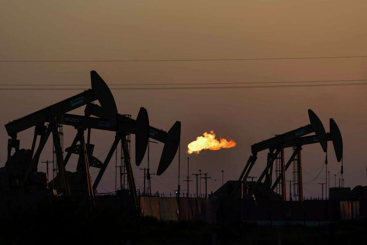 FILE - A flare burns off methane and other hydrocarbons as oil pumpjacks operate in the Permian Basin in Midland, Texas, Tuesday, Oct. 12, 2021. Under the Biden administration's Inflation Reduction Act, companies must start producing precise measurements of their methane emissions next year or face fines.