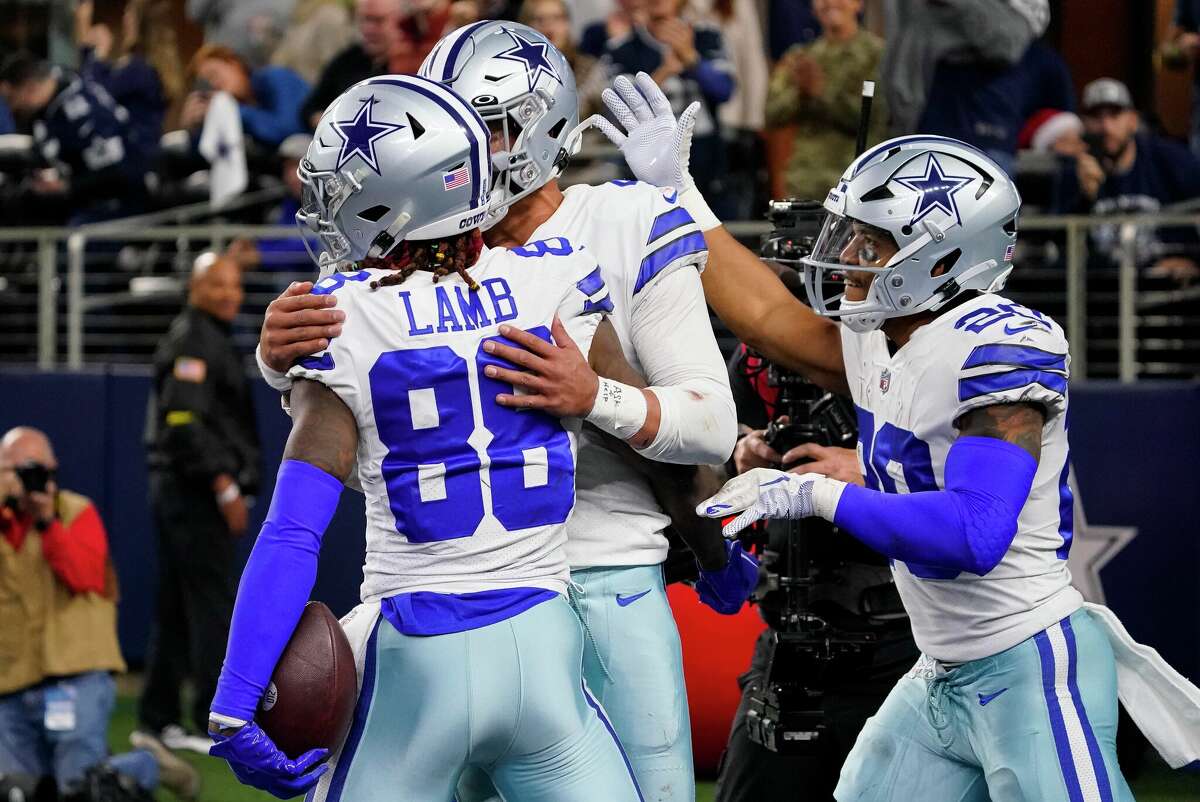 CeeDee Lamb of the Dallas Cowboys is congratulated by Dak Prescott and Tony Pollard during the fourth quarter against the Philadelphia Eagles on Dec. 24, 2022, in Arlington.
