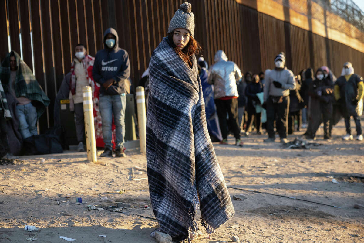 Colombian immigrant Gisele, 18, bundles up against the cold after spending the night camped alongside the U.S.-Mexico border fence on December 22, 2022 in El Paso, Texas. A spike in the number of migrants seeking asylum in the United States has challenged local, state and federal authorities. 