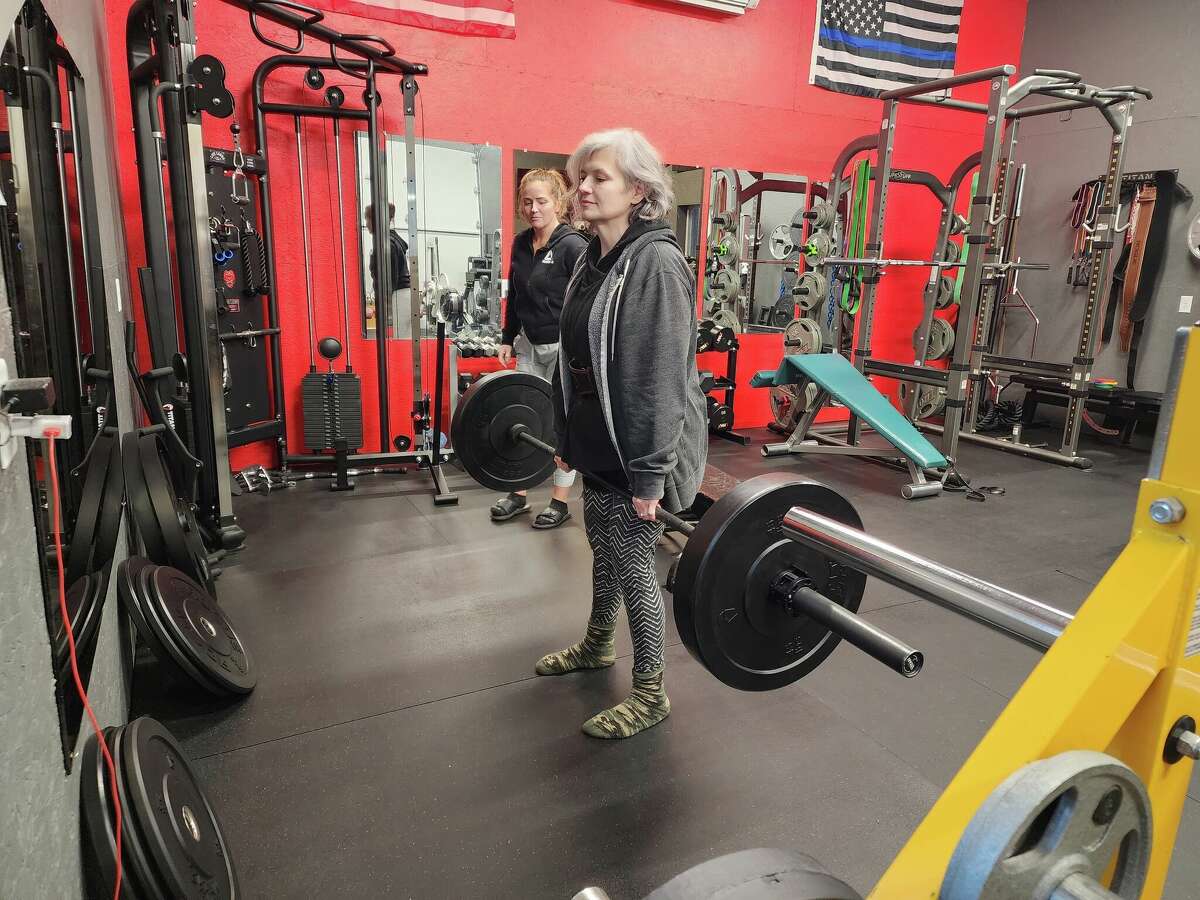 Manistee's Paula Laws (center) works on her deadlift form during a training session on Jan. 30, 2023.