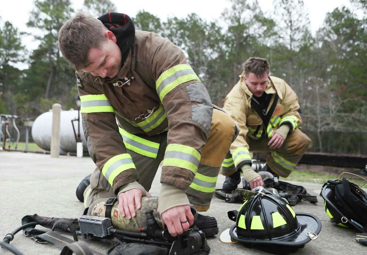 Cadet Sean Bunch, left, checks his gear alongside Jackson Burrowes during a training session for The Woodlands Fire Department at The Woodlands Emergency Training Center, Tuesday, Jan. 31, 2023, in The Woodlands.