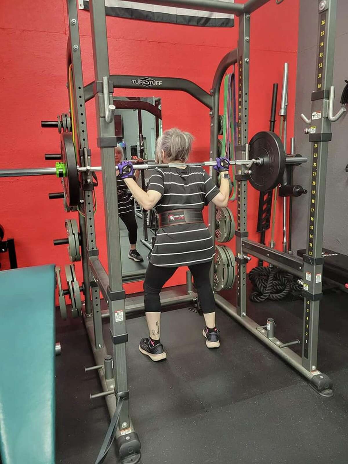 Paula Laws goes through a back squat workout.