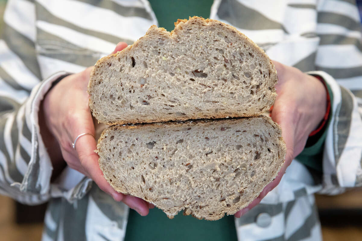 Lehr's German Specialties new owner Hannah Seyfert holds a wheat and rye bread that is one of the German food items available at her store in the Noe Valley of San Francisco, Calif. on Jan. 29, 2023.