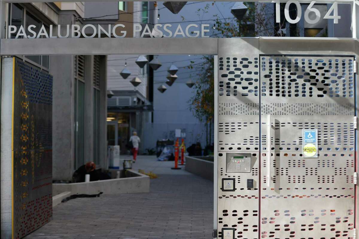 新しい恒久的な支援住宅の建物である 1064 ミッションにある、居住者と一般市民のための共有屋外スペースであるパサルボン パッセージの看板。
