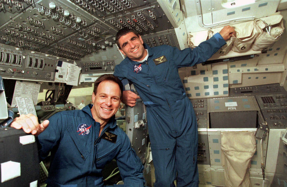 Israeli astronauts Ilan Ramon, left, and Itzhak Mayo stand on the flight deck of a model space shuttle at NASA's Johnson Space Center on July 16, 1998, in Houston.  Ramon was selected in 1997 to be the payload specialist.  Much of Columbus' 16-day voyage was spent pointing cameras at an Israel Space Agency study of how desert dust and other pollutants in Earth's atmosphere affect precipitation and temperature. 