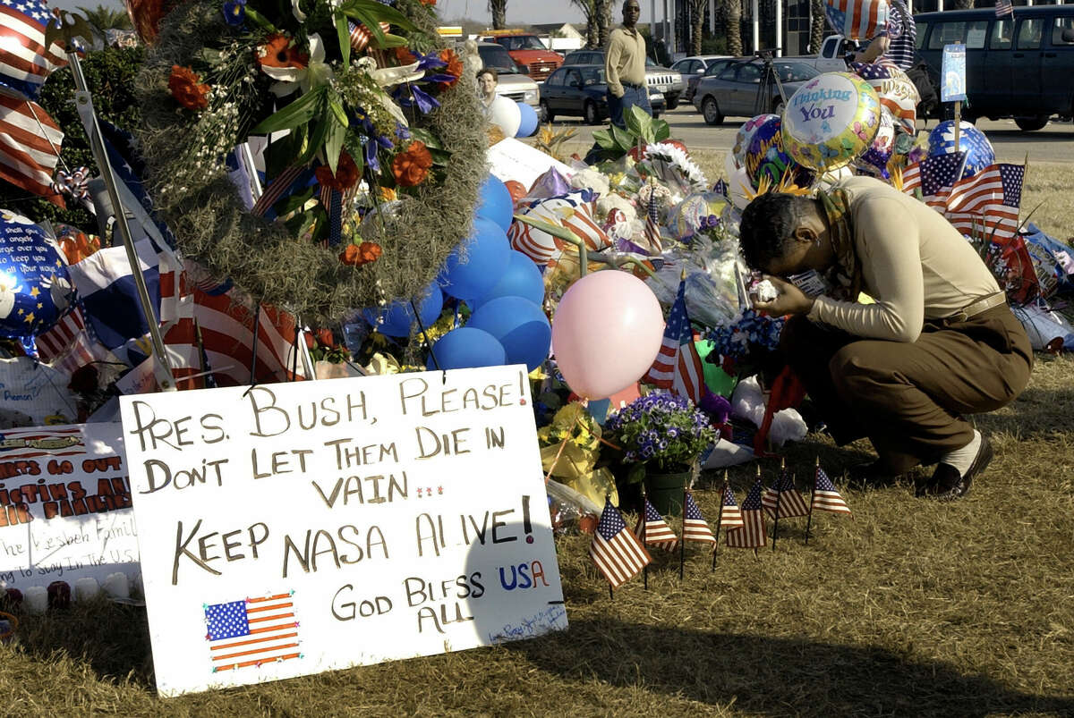 NASA contractor Ingrid Walker kneels to pray at a memorial to the seven astronauts who lost their lives in the space shuttle Columbia accident in front of NASA's Johnson Space Center Monday, Feb. 3, 2003 in Houston.  The seven astronauts aboard Columbia lost their lives Saturday when the shuttle broke up during its descent into Earth's atmosphere. 