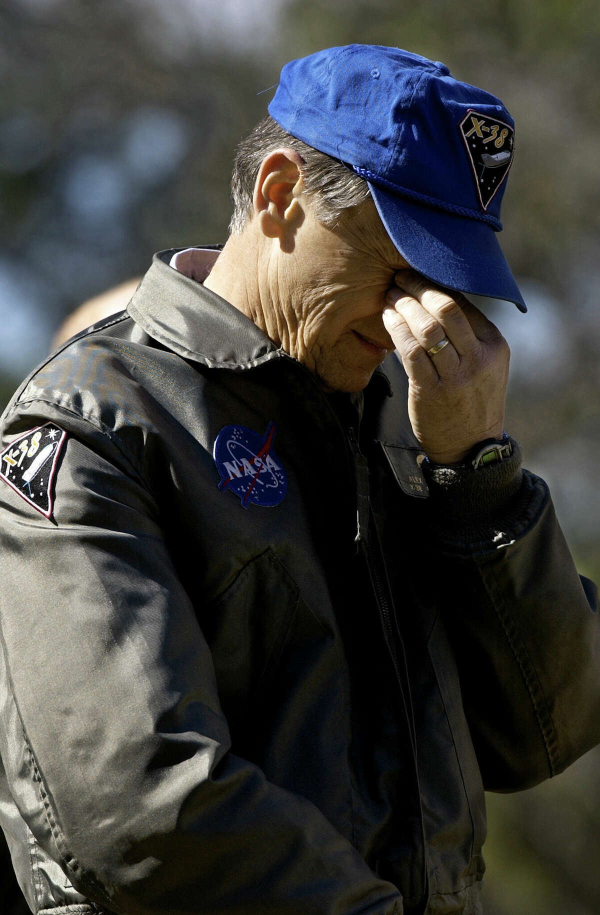 NASA test engineer Alex Dola bows his head while watching a memorial service Tuesday, February 4, 2003 in Houston for the seven astronauts lost on the space shuttle Columbia. 