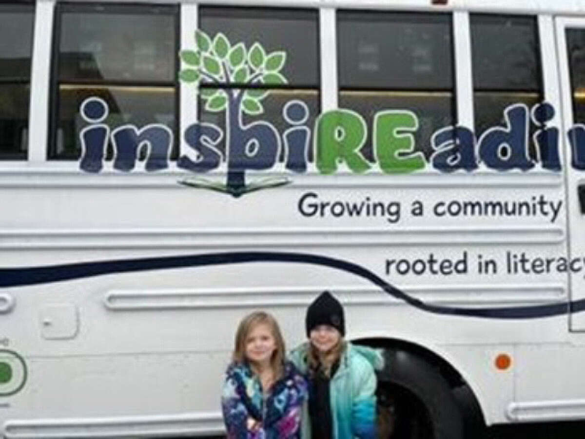 Students pose in front of the inspiREading book bus during Family Literacy Night at Baldwin Elementary. 