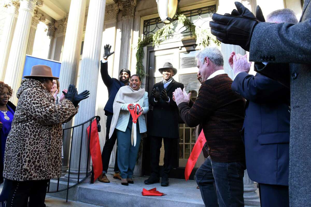 Deshanna Wiggins, chief executive officer of The Albany Black Chamber of Commerce and Social Club, center, holds the scissors after cutting a ribbon to mark the opening of the Albany Black Chamber of Commerce & Social Club on Wednesday, Feb. 1, 2023, a the former University Club on Washington Ave. in Albany, N.Y. The project, aimed at nurturing Black and minority businesses, was supported through a grant from Business for Good. Its opening marks the beginning of Black History Month.