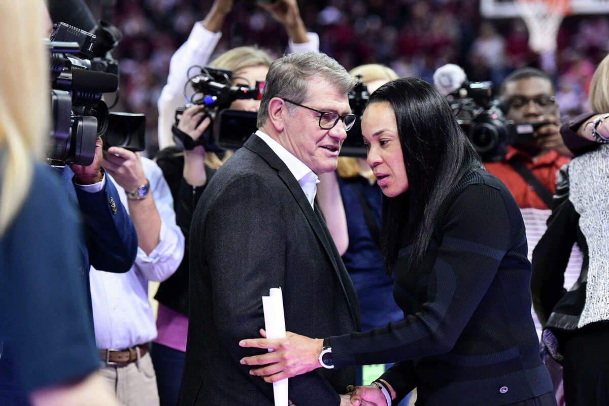 Connecticut coach Geno Auriemma, left, and South Carolina coach Dawn Staley shake hands before an NCAA college basketball game Monday, Feb. 10, 2020, in Columbia, S.C. South Carolina defeated Connecticut 70-52. (AP Photo/Sean Rayford)