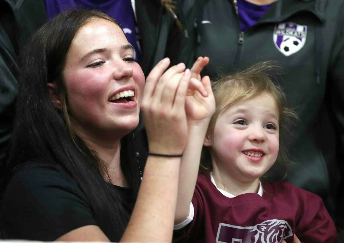 Willis soccer player Lucy Smith, left, fixes the Texas Southern University hand sign of her five-year-old sister, Sammi Jo, after a ceremony on National Singing Day at Willis High School, Wednesday, Feb. 1, 2023, in Willis.
