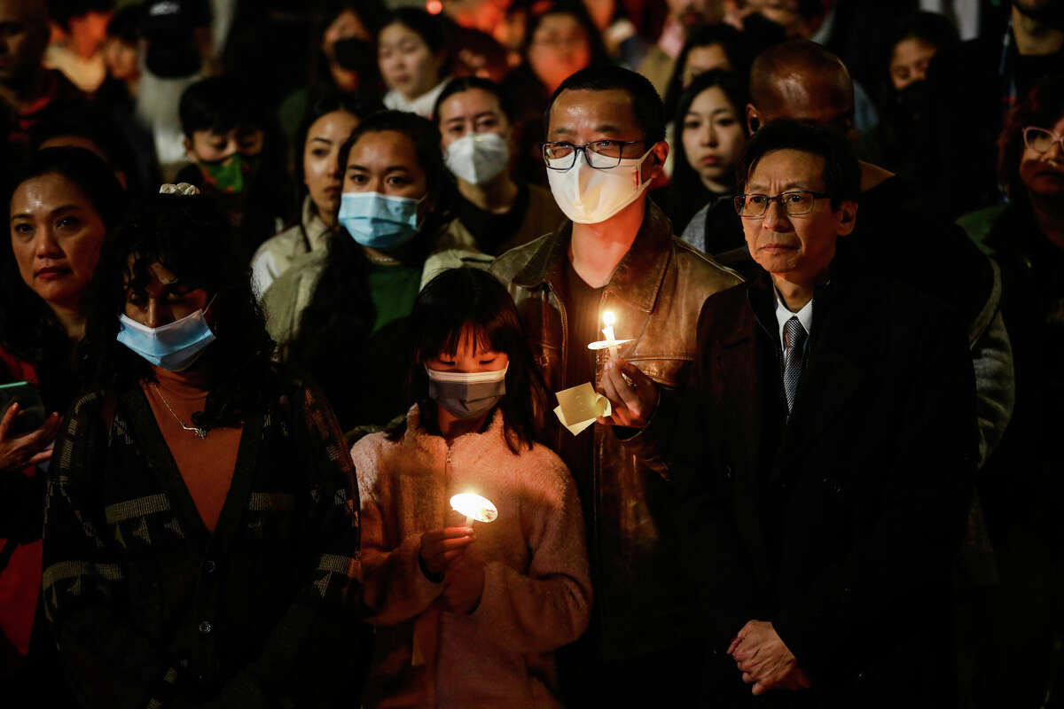 Leto Sze, 9, (bottom, center) and father Michael Sze (center, right) attend the AAPI Unite Candlelight Vigil for the victims of the Monterey Park, Half Moon Bay and East Oakland shootings in Oakland on Jan 25.