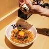 Dried garlic is being grounded into a bowl of Nikumori Minced Pork Aburasoba at Kajiken, a Japanese restaurant chain that specializes in soupless ramen noodles, also commonly referred to as abura soba, at its first Bay Area location in San Mateo, Calif., Tuesday, Jan. 31, 2023.