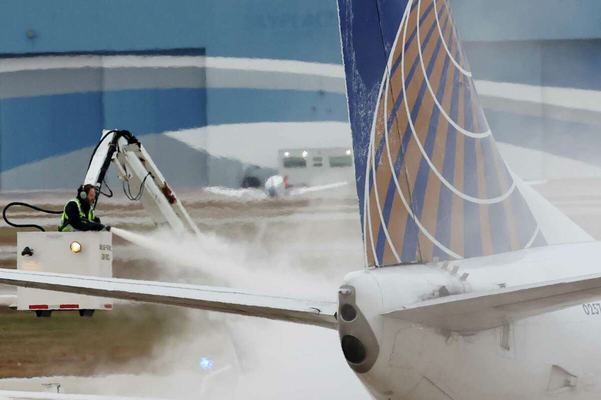 San Antonio International Airport crews de-ice planes before take off, Wednesday, Feb. 1, 2023. A strong cold front blew through the area lowering temperatures into the low 30’s with ice accumulations and power outages.