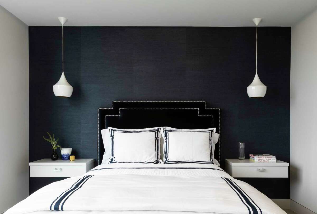 Navy blue grasscloth wallpaper covers a feature wall in the guest bedroom.