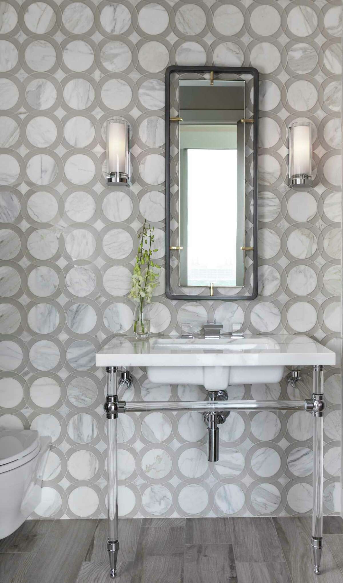 A wall of beautiful marble tile dresses up the powder bathroom.