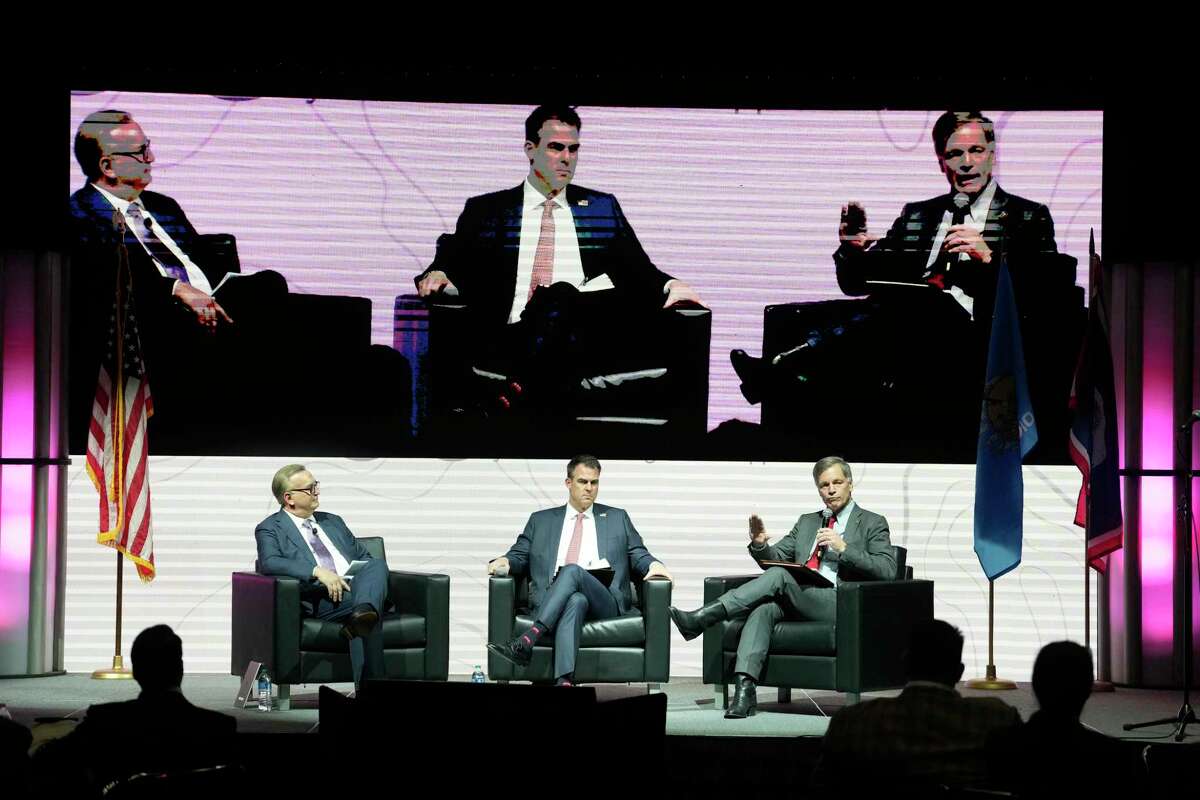 Carl Campbell, co-founder and COO Alamo Resources, left, moderates a panel discussion with Oklahoma Governor J. Kevin Stitt, center, and Wyoming Governor Mark Gordon, right, during the NAPE Summit, an annual oil and gas conference, at the George R. Brown Convention Center Wednesday, Feb. 1, 2023, in Houston.