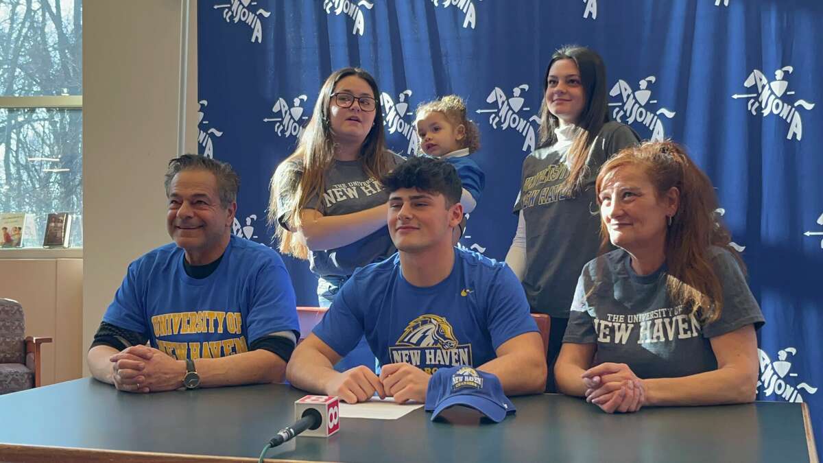 Ansonia running back David Cassetti (center) during his football National Signing Day Ceremony at Ansonia High School, Wednesday, Feb. 1, 2023. His father, Ansonia mayor David Cassetti is seated at left.