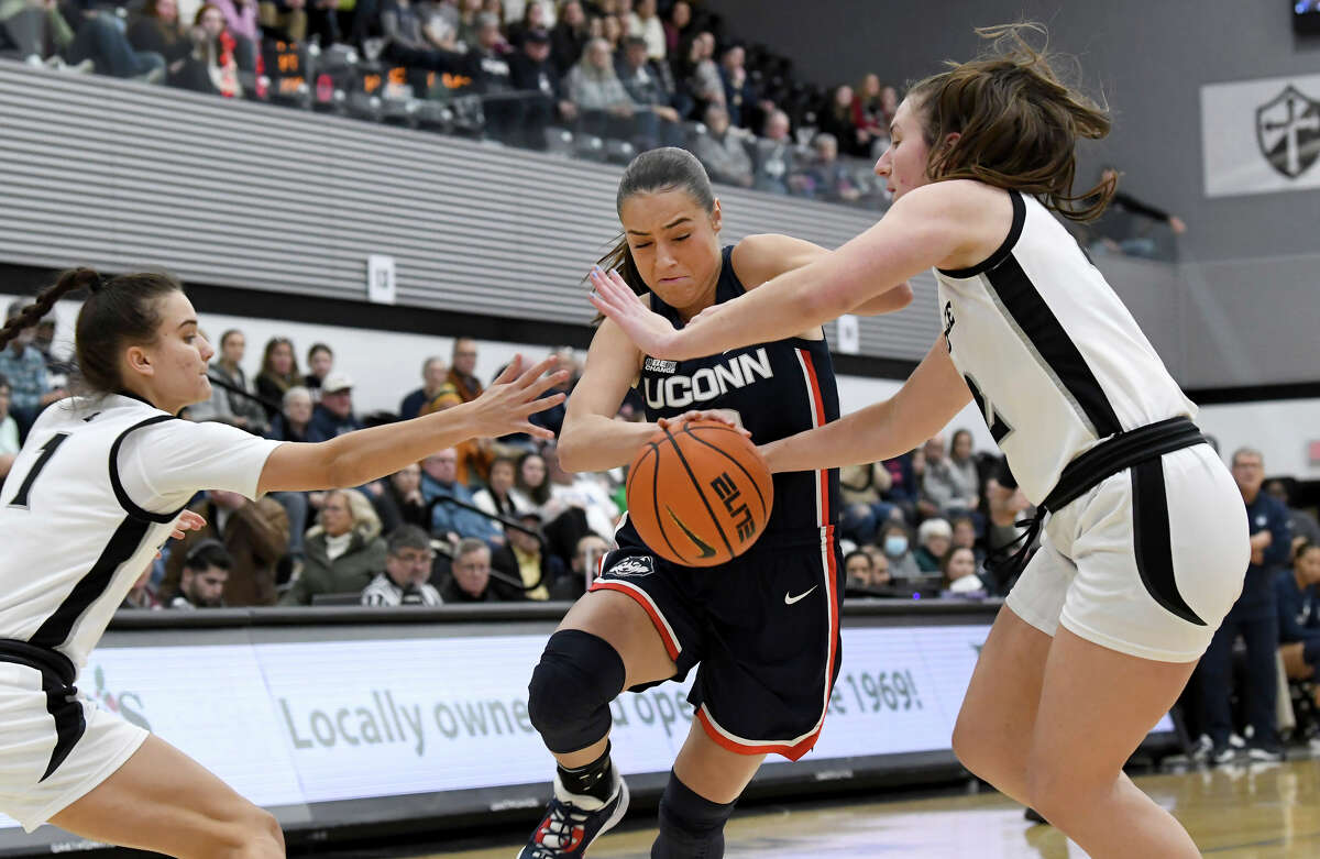 UConn's Nika MÃ¼hl, center, drives the ball past Providence's Kylee Sheppard, left, and Brynn Farrell in the first half of an NCAA college basketball game, Wednesday, Feb. 1, 2023, in Providence, R.I. (AP Photo/Mark Stockwell)